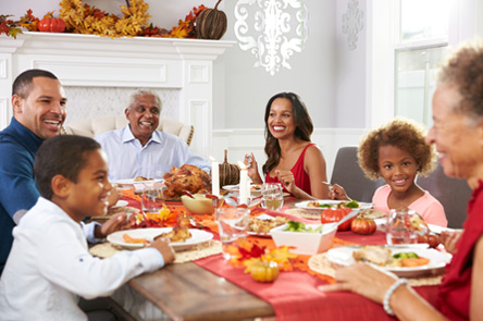 Family-With-Grandparents-Enjoying-Thanksgiving-Meal-At-Table